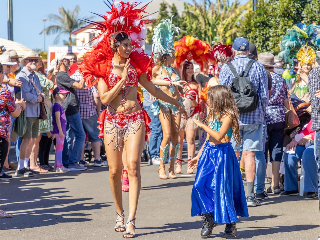 Performers in colourful festival costumes interact with spectators during the Childers Festival near Bundaberg, Queensland.