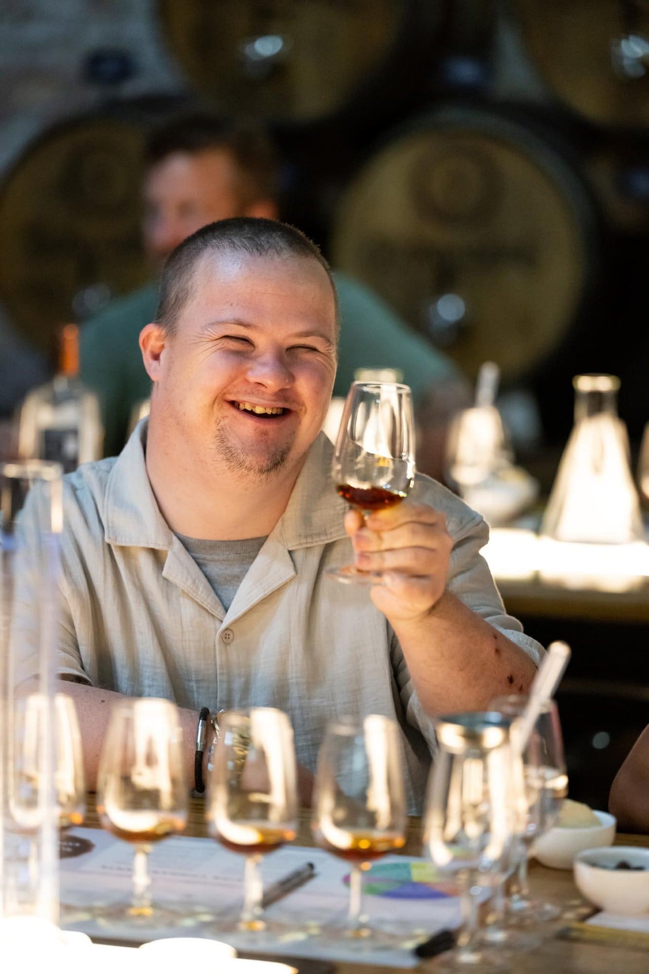 Person living with disability looking into shallow rum glass and swirling to mix their signature rum blend.